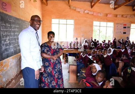 Songea, Tansania. November 2023. Joe Chialo (CDU), Berliner Senator für Kultur und sozialen Zusammenhalt, der Präsident Steinmeier auf seiner Reise als Gast begleitet, steht während des Besuchs der Maji-Maji Primary School in Songea in einem Klassenzimmer und spricht dort mit Schülern. Quelle: Bernd von Jutrczenka/dpa/Alamy Live News Stockfoto