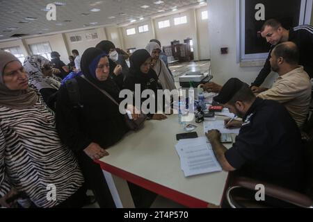 Rafah, Palästinensische Gebiete. November 2023. Menschen warten am Grenzübergang zwischen dem Gazastreifen und Ägypten in Rafah. Verletzte Palästinenser, Palästinenser mit zweiten Pässen und Ausländer können über den Grenzübergang Rafah evakuiert werden. Quelle: Mohammed Talatene/dpa/Alamy Live News Stockfoto