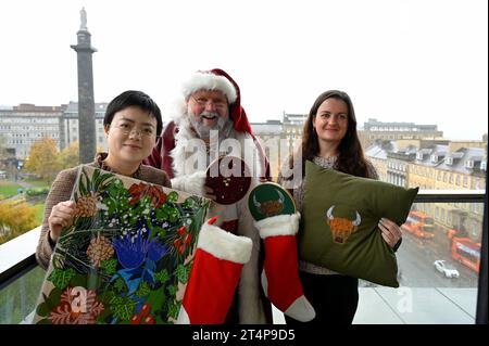 Edinburgh, Schottland, Großbritannien. November 2023. Der Weihnachtsmann fliegt dieses Jahr zu Edinburghs Weihnachten in die Stadt und besucht den Balkon von Harvey Nichols und wird dann seinen Wohnsitz am St. Andrew Square einnehmen. Der Weihnachtsmann und die lokalen Weihnachtsstandhalter füllen Strümpfe mit Geschenken, die auf dem Weihnachtsmarkt erhältlich sind. Mit über 70 Ständen und Besucherattraktionen finden die Weihnachtsfeiern in Edinburgh von Freitag, dem 17. November, bis Samstag, den 6. Januar 2024, statt. Stallhalter Luna Xue - Westmount Art und Sammy Bishop - Paraffle with Santa Claus. Quelle: Craig Brown/Alamy Live News Stockfoto