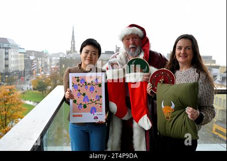 Edinburgh, Schottland, Großbritannien. November 2023. Der Weihnachtsmann fliegt dieses Jahr zu Edinburghs Weihnachten in die Stadt und besucht den Balkon von Harvey Nichols und wird dann seinen Wohnsitz am St. Andrew Square einnehmen. Der Weihnachtsmann und die lokalen Weihnachtsstandhalter füllen Strümpfe mit Geschenken, die auf dem Weihnachtsmarkt erhältlich sind. Mit über 70 Ständen und Besucherattraktionen finden die Weihnachtsfeiern in Edinburgh von Freitag, dem 17. November, bis Samstag, den 6. Januar 2024, statt. Stallhalter Luna Xue - Westmount Art und Sammy Bishop - Paraffle with Santa Claus. Quelle: Craig Brown/Alamy Live News Stockfoto