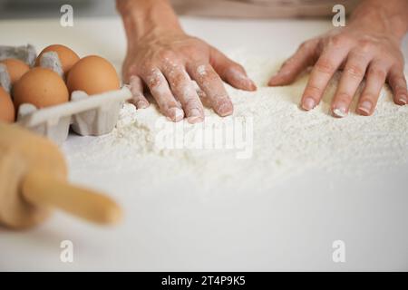 Die Anfänge eines leckeren Leckerbissen. Nahaufnahme einer Frau, die Teig macht. Stockfoto