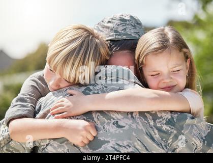 Die Welt, die die Ehe entdeckt hat, liebt dich nicht wie deine Familie. Ein Vater, der von der Armee zurückkehrt, umarmt seine Kinder draußen. Stockfoto