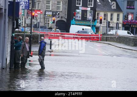 Die Menschen laufen durch das Hochwasser in Sugar Island, Newry Town, Co Down, das von Hochwasser überschwemmt wurde, als der Kanal der Stadt bei starken Regenfällen seine Ufer platzte. Dutzende von Unternehmen wurden von den Überschwemmungen heimgesucht, mit weitreichenden Schäden an Gebäuden, Einrichtungen und Lagerbeständen. Bilddatum: Mittwoch, 1. November 2023. Stockfoto