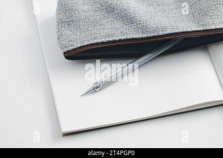 Mechanischer Bleistift in einem Bleistiftetui auf einem weißen Notizbuch. Stockfoto