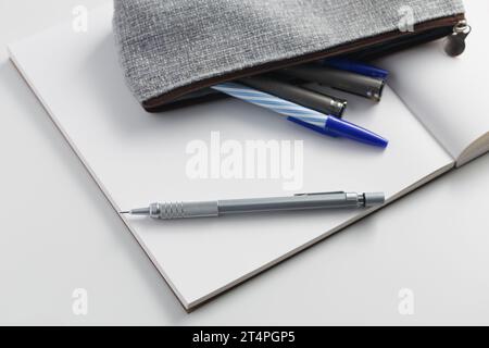 Mechanischer Bleistift in einem Bleistiftetui auf einem weißen Notizbuch. Stockfoto