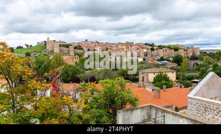 Avila Stadt hohe Landschaft mit berühmten mittelalterlichen Stadtmauern mit Zinnen, gotischer Architektur und grüner Vegetation rund um Spanien Stockfoto