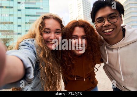 Eine Gruppe von Schülerfreunden, die Spaß im Freien haben, um ein Selfie zu machen und die Kamera lächelnd anzuschauen. Stockfoto