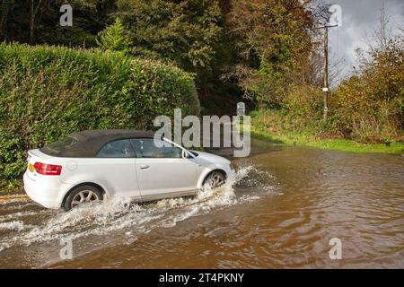 Swansea, Großbritannien. November 2023. Ein Auto fährt heute durch die überflutete Straße zum Parc Le Breos auf der Gower-Halbinsel in Swansea, als der Sturm Ciarán durch Großbritannien zieht und starke Winde und sintflutartige Regenfälle mit sich bringt. Quelle: Phil Rees/Alamy Live News Stockfoto