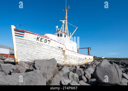 Keflavik, Island - 11. Juli 2023: Das Schiffswrack-Fischerboot Baldur (1961) liegt an einem sonnigen Tag auf Felsen. Stockfoto