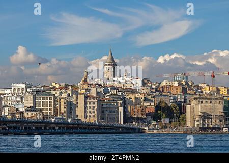 Istanbul, Türkei - 19. Oktober 2023: Menschen, die über die Galata-Brücke gehen, mit Galata-Turm im Hintergrund, aufgenommen vom Goldenen Horn Stockfoto