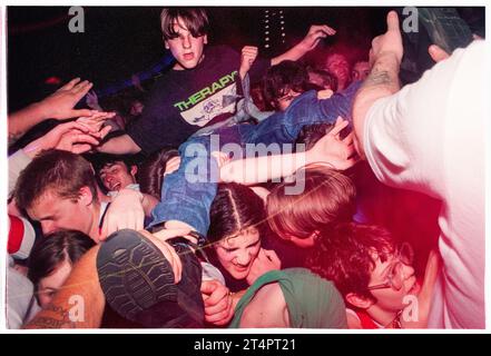 CROWD SURFING BOY, NEWPORT CENTRE, 1996: Junge Britpop-Fans in der Menge kämpfen gegen die Sicherheitsbarriere während des Ash-Konzerts im Newport Centre in Newport, Wales, Großbritannien am 21. Mai 1996. Foto: Rob Watkins Stockfoto