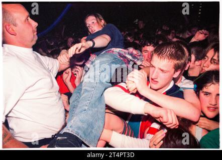 CROWD SURFING BOY, NEWPORT CENTRE, 1996: Junge Britpop-Fans in der Menge kämpfen gegen die Sicherheitsbarriere während des Ash-Konzerts im Newport Centre in Newport, Wales, Großbritannien am 21. Mai 1996. Foto: Rob Watkins Stockfoto