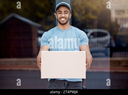 Ich kam so schnell ich konnte hierher. Porträt eines jungen Liefermannes, der eine Kiste hält. Stockfoto
