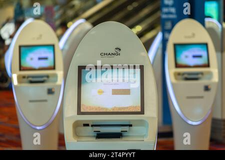 Automatisierte Check-in-Automaten am Changi Airport Terminal bieten schnellen Service und das Drucken von Bordkarten für ausgewählte Fluggesellschaften – ideal für redaktionelle Zwecke. Stockfoto