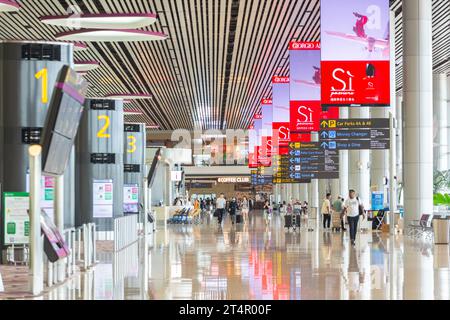 Der Abflugbereich des Flughafens Changi Terminal 4 ist Tageslichtdurchdringung, um Energie zu sparen, und die großen Lichtpaneele geben dem Innenraum ein lebendigeres Erlebnis. Stockfoto
