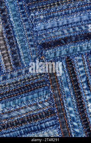 Diagonales Denim-Muster im Patchwork-Stil aus Nähten alter Jeans. Stockfoto