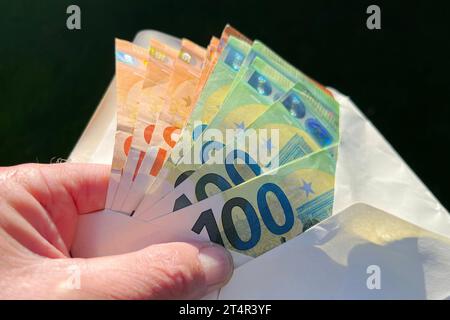 Themenbild,Symbolfoto:Hand greift Geldscheine in einem geoeffneten Umschlag Euro,Sparer,Geld,Bargeld,Geldschein,Geldscheine. Euro Banknoten, Inflation, Sparer, Finderlohn. *** Themenbild, Symbol Foto Hand greift Banknoten in einem geöffneten Umschlag Euro, Sparer, Geld, Bargeld, Banknote, Banknoten Euro-Banknoten, Inflation, Sparer, Finderbelohnung Stockfoto