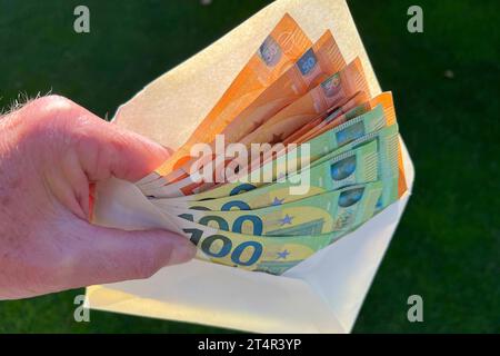 Themenbild,Symbolfoto:Hand greift Geldscheine in einem geoeffneten Umschlag Euro,Sparer,Geld,Bargeld,Geldschein,Geldscheine. Euro Banknoten, Inflation, Sparer, Finderlohn. *** Themenbild, Symbol Foto Hand greift Banknoten in einem geöffneten Umschlag Euro, Sparer, Geld, Bargeld, Banknote, Banknoten Euro-Banknoten, Inflation, Sparer, Finderbelohnung Stockfoto