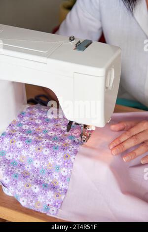 Hände der Schneiderin, die Stoff mit Nähmaschine näht. Stockfoto