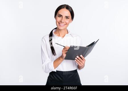 Foto-Porträt einer lächelnden Frau, die Ordnung in einem Café aufschreibt, isoliert auf weißem Hintergrund Stockfoto