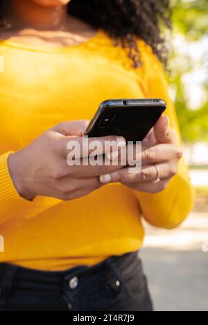 Vertikale Nahaufnahme der Hände einer jungen Afroamerikanerin, die im Internet surft. Stockfoto