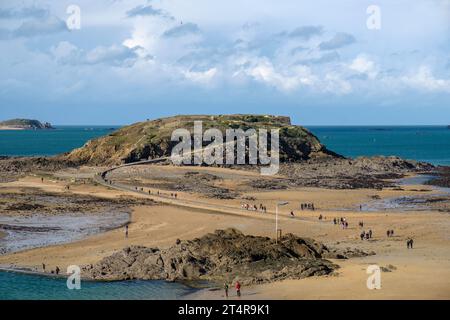 Menschen auf dem gewundenen Damm zur Gezeiteninsel Tombeau de Chateaubriand vor den Mauern von St., Malo, Bretagne Stockfoto