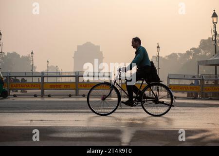 Neu-Delhi, Indien. November 2023. Ein Radfahrer, der zur Arbeit geht, gesehen am India Gate an einem frühen Smoke Morgen. Die Luftverschmutzung in Delhi ist in erster Linie auf Fahrzeuge, Industrien, Baustaub, Abfallverbrennung und Verbrennung von Erntegutrückständen zurückzuführen. Im Winter verschärfen Temperaturumkehrungen das Problem, indem Schadstoffe in Bodennähe eingeschlossen werden. (Credit Image: © Pradeep Gaur/SOPA Images via ZUMA Press Wire) NUR REDAKTIONELLE VERWENDUNG! Nicht für kommerzielle ZWECKE! Stockfoto