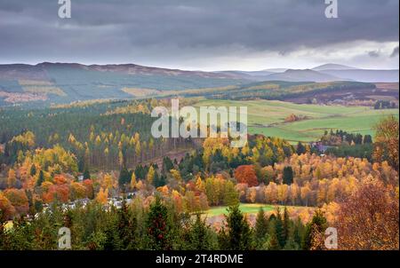 Balmoral Estates Crathie Scotland mit Blick auf das Dee-Tal zu Häusern und Brennereien, nebelbedeckten Hügeln und bunten Bäumen und Blättern im Herbst Stockfoto