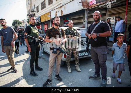 Jenin, Palästina. November 2023. Bewaffnete Männer nehmen an der Beerdigung von drei Palästinensern Teil, die bei einem israelischen Militärangriff in einem Flüchtlingslager von Dschenin im besetzten nördlichen Westjordanland erschossen wurden. Quelle: SOPA Images Limited/Alamy Live News Stockfoto