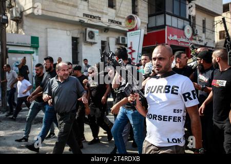 Jenin, Palästina. November 2023. Bewaffnete Männer nehmen an der Beerdigung von drei Palästinensern Teil, die bei einem israelischen Militärangriff in einem Flüchtlingslager von Dschenin im besetzten nördlichen Westjordanland erschossen wurden. Quelle: SOPA Images Limited/Alamy Live News Stockfoto