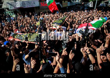 Jenin, Palästina. November 2023. ANMERKUNG DES HERAUSGEBERS: Das Bild zeigt den Tod Mourners trägt die Leichen von drei Palästinensern, die bei einem israelischen Militärangriff in einem Flüchtlingslager von Dschenin im besetzten nördlichen Westjordanland erschossen wurden. Quelle: SOPA Images Limited/Alamy Live News Stockfoto