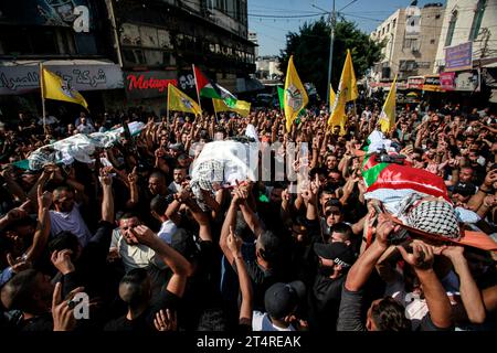 Jenin, Palästina. November 2023. ANMERKUNG DES HERAUSGEBERS: Das Bild zeigt den Tod Mourners trägt die Leichen von drei Palästinensern, die bei einem israelischen Militärangriff in einem Flüchtlingslager von Dschenin im besetzten nördlichen Westjordanland erschossen wurden. (Foto: Nasser Ishtayeh/SOPA Images/SIPA USA) Credit: SIPA USA/Alamy Live News Stockfoto