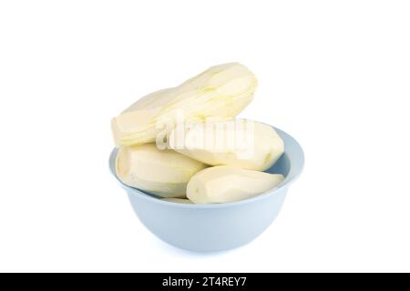 Geschälte, reife, rohe Zucchini in einer blauen Schüssel auf weißem Hintergrund. Kopierbereich. Stockfoto