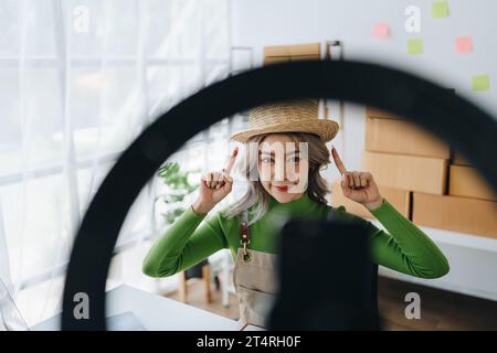 Schöne asiatische Frau, Bloggerin, Blog, Präsentation der Produktqualität, Live-Video, soziale Medien, Aufnahme, Online-Verkauf über Digitalkameras, kmu oder kleine Unternehmen Stockfoto