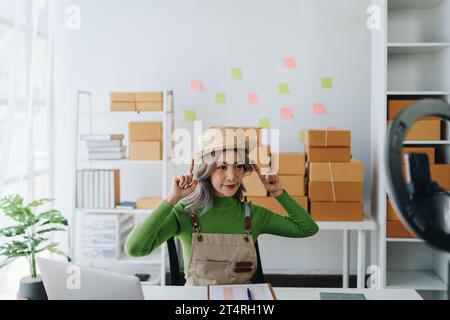 Schöne asiatische Frau, Bloggerin, Blog, Präsentation der Produktqualität, Live-Video, soziale Medien, Aufnahme, Online-Verkauf über Digitalkameras, kmu oder kleine Unternehmen Stockfoto