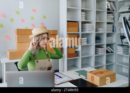 Schöne asiatische Frau, Bloggerin, Blog, Präsentation der Produktqualität, Live-Video, soziale Medien, Aufnahme, Online-Verkauf über Digitalkameras, kmu oder kleine Unternehmen Stockfoto