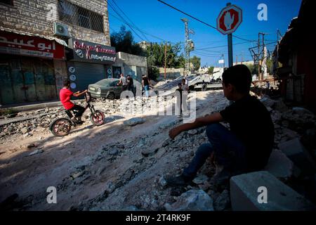 Jenin, Palästina. November 2023. Palästinenser untersuchen die Schäden an den Gebäuden und Straßen nach einem israelischen Militärangriff im Flüchtlingslager Jenin im besetzten nördlichen Westjordanland. Laut Berichten von Gesundheitsbeamten sind bei den israelischen Militärangriffen im besetzten Westjordanland 115 Menschen tot und mehr als 1100 verletzt worden. Diese Zahlen wurden seit dem Ausbruch des jüngsten Konflikts zwischen Israel und der militanten palästinensischen Hamas im Gazastreifen verzeichnet. Quelle: SOPA Images Limited/Alamy Live News Stockfoto