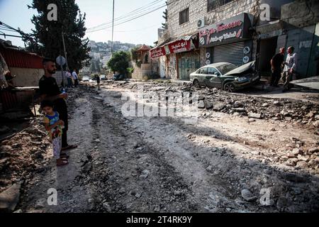 Jenin, Palästina. November 2023. Palästinenser untersuchen die Schäden an den Gebäuden und Straßen nach einem israelischen Militärangriff im Flüchtlingslager Dschenin im besetzten nördlichen Westjordanland. Laut Berichten von Gesundheitsbeamten sind bei den israelischen Militärangriffen im besetzten Westjordanland 115 Menschen tot und mehr als 1100 verletzt worden. Diese Zahlen wurden seit dem Ausbruch des jüngsten Konflikts zwischen Israel und der militanten palästinensischen Hamas im Gazastreifen verzeichnet. Quelle: SOPA Images Limited/Alamy Live News Stockfoto