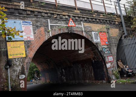 Werbeanzeigen für lokale Unternehmen werden am 1. November 2023 auf einer Eisenbahnbrücke in Loughborough Junction in London, England, ausgestellt. Loughborough Junction im südlichen Londoner Stadtteil Lambeth wird bald einer umfassenden Umgestaltung und Sanierung unterzogen, da nahe gelegene Hochhäuser und flache Komplexe jüngere Einheimische anziehen Stockfoto