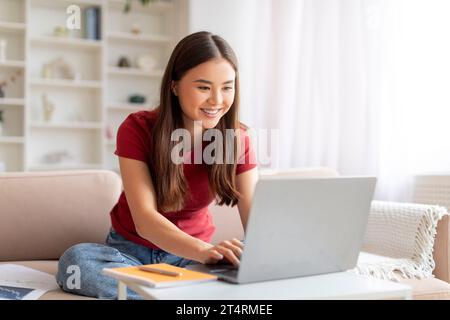 Freiberufliches Konzept. Glückliche Junge Asiatische Frau, Die Zu Hause An Laptop Arbeitet Stockfoto