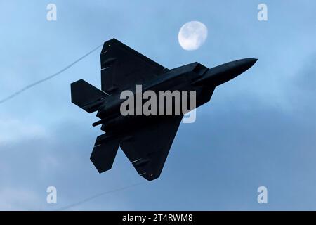 Anchorage, Usa. 31. Oktober 2023. Ein F-22 Raptor-Kampfflugzeug der US Air Force, das dem 3rd Wing zugewiesen wurde, startet am 31. Oktober 2023 auf der Joint Base Elmendorf-Richardson in Anchorage (Alaska) an einem aufsteigenden Mond vorbei. Quelle: SRA Julia Lebens/Planetpix/Alamy Live News Credit: Planetpix/Alamy Live News Stockfoto