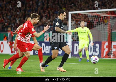 Freiburg Im Breisgau, Deutschland. November 2023. Fußball: DFB-Cup, SC Freiburg - SC Paderborn 07, 2. Runde, im Europa-Park-Stadion. Paderborns Adriano Grimaldi (Mitte) im Kampf gegen Freiburger Noah Weißhaupt (Front l) und Kiliann Eric Sildillia. Quelle: Philipp von Ditfurth/dpa – WICHTIGER HINWEIS: gemäß den Vorgaben der DFL Deutsche Fußball Liga und des DFB Deutscher Fußball-Bund ist es verboten, im Stadion und/oder des Spiels aufgenommene Fotografien in Form von Sequenzbildern und/oder videoähnlichen Fotoserien zu verwenden oder zu verwenden./dpa/Alamy Live News Stockfoto