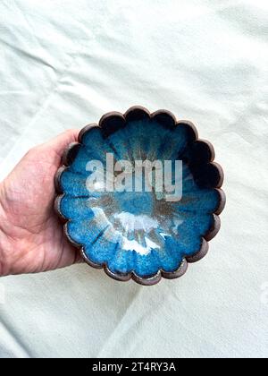 Eine handgefertigte Muschelschale aus Keramik in blauer Glasur Stockfoto
