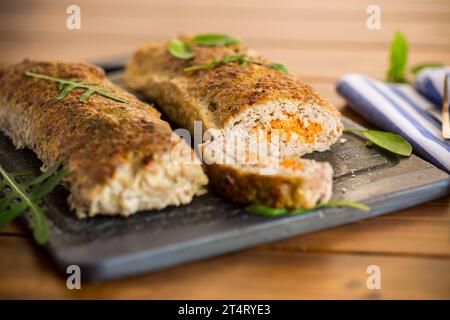 Gekochter Hackbraten mit Gemüsefüllung innen auf einem Holztisch. Stockfoto