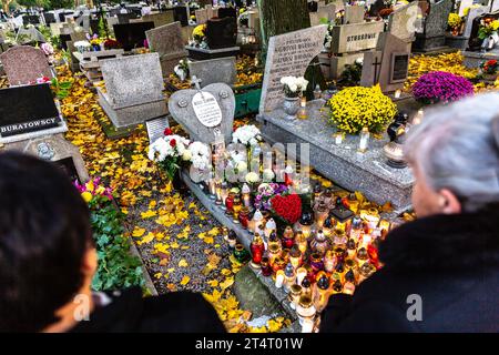 Krakau, Polen. November 2023. Frauen beten am 1. November 2023 an einem mit Blumen und Kerzen geschmückten Grab auf dem Rakowicki-Friedhof in Krakau Polen. Allerheiligen in Polen ist ein sehr traditioneller Familienurlaub. Menschenmassen besuchen Friedhöfe im ganzen Land, um Kerzen anzuzünden und Blumen für die Verstorbenen zu bringen. (Foto: Dominika Zarzycka/SIPA USA) Credit: SIPA USA/Alamy Live News Stockfoto