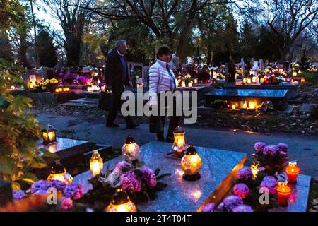 Krakau, Polen. November 2023. Am 1. November 2023 spazieren die Menschen zwischen Gräbern, die mit Blumen und Kerzen geschmückt sind, auf dem Rakowicki-Friedhof in Krakau, Polen. Allerheiligen in Polen ist ein sehr traditioneller Familienurlaub. Menschenmassen besuchen Friedhöfe im ganzen Land, um Kerzen anzuzünden und Blumen für die Verstorbenen zu bringen. (Foto: Dominika Zarzycka/SIPA USA) Credit: SIPA USA/Alamy Live News Stockfoto