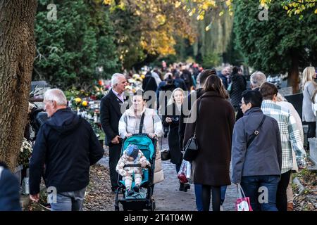 Krakau, Polen. November 2023. Am 1. November 2023 laufen die Menschenmassen zwischen Gräbern, die mit Blumen und Kerzen geschmückt sind, auf dem Rakowicki-Friedhof in Krakau Polen. Allerheiligen in Polen ist ein sehr traditioneller Familienurlaub. Menschenmassen besuchen Friedhöfe im ganzen Land, um Kerzen anzuzünden und Blumen für die Verstorbenen zu bringen. (Foto: Dominika Zarzycka/SIPA USA) Credit: SIPA USA/Alamy Live News Stockfoto