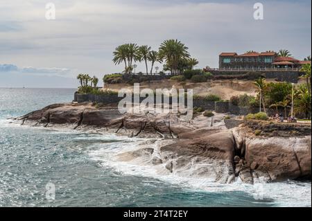 Spektakuläre Küste von Costa Adeja, Teneriffa. Der atlantik stürzt gegen die felsige Landzunge, wo exotische Palmen zu sehen sind. Stockfoto