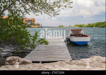 Kleine, farbenfrohe Ruderboote, die neben einem Holzsteg auf der Karibikinsel Curacao auf den Niederländischen Antillen vor Anker gehen Stockfoto