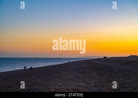 Fshermen fischen am Strand von Dungeness, Kent, bei Sonnenuntergang Stockfoto